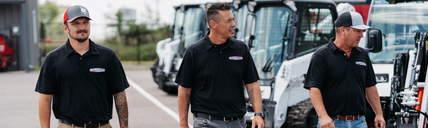 Employees viewing the variety of bobcat equipment in the outside yard
