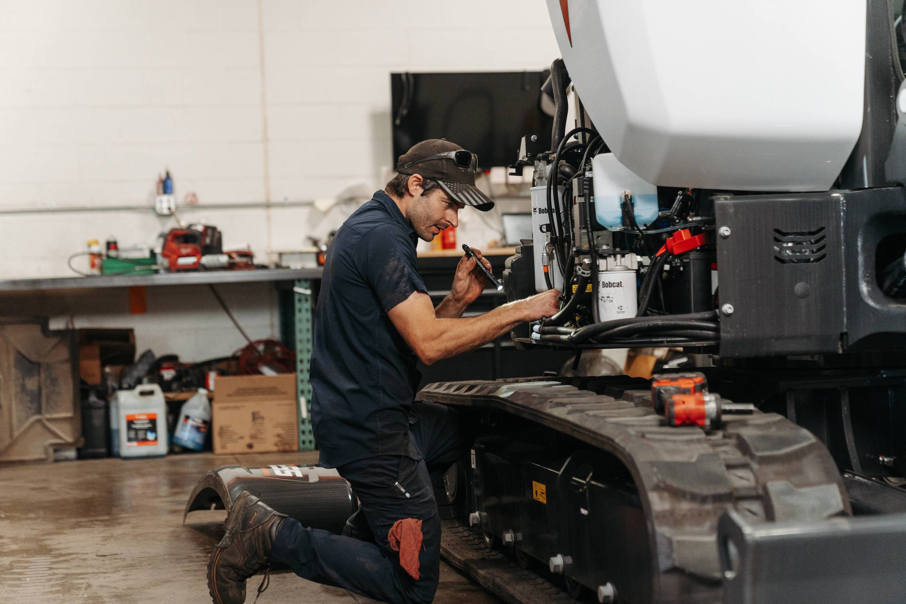 employee reparing bobcat excavator