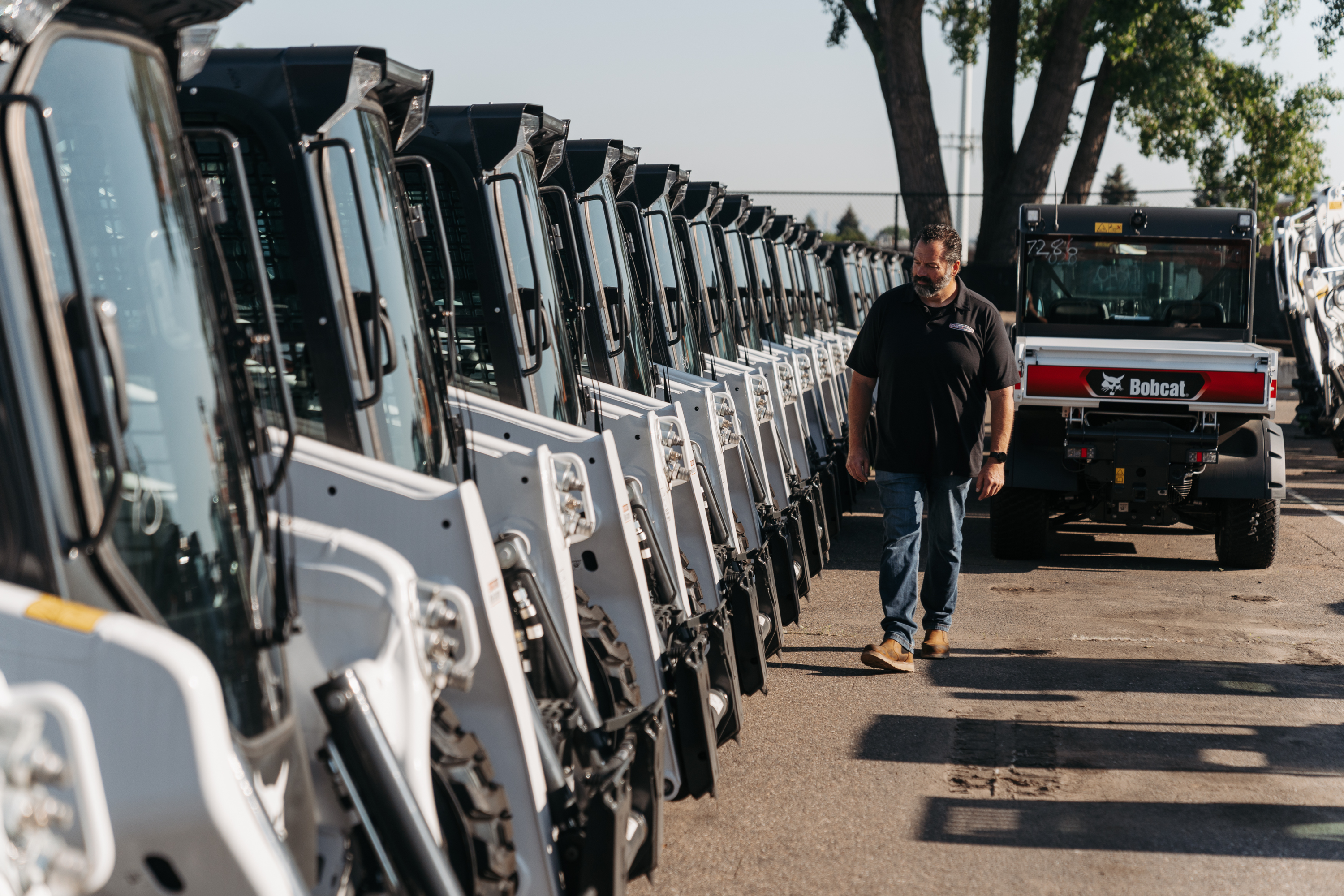 Employee walking near bobcat lineup